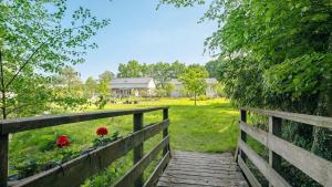 a wooden boardwalk leading to a field with red flowers at Gites de l'hivet in Merdrignac