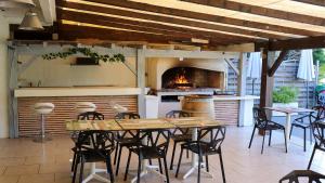 a patio with a table and chairs and an oven at Hôtel-Restaurant La Belle Poule - in Rochefort