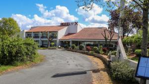 a hotel building with a road in front of it at Hôtel-Restaurant La Belle Poule - in Rochefort