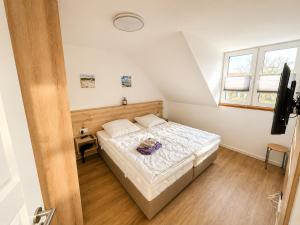 a bedroom with a bed and a window at Inselheimat Dranske in Dranske