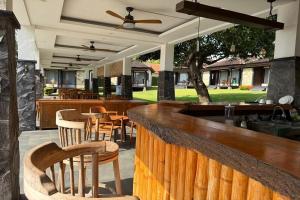 a bar with wooden chairs and tables in a restaurant at Hi Blue Bali Melasti Dive Resort in Karangasem