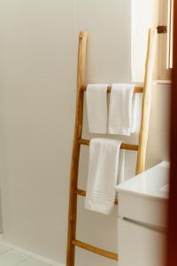 a towel rack in a bathroom with white towels at Casa da Areia - by RowdHouses - Private Beach Access in Praia da Barra +22 photos