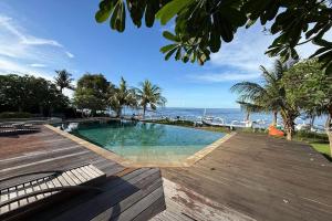 a swimming pool on a deck with the ocean in the background at Hi Blue Bali Melasti Dive Resort in Karangasem