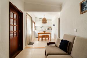 a living room with a couch and a table at Casa da Areia - by RowdHouses - Private Beach Access in Praia da Barra