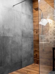 a shower with a glass door in a bathroom at Apartamenty Pod Kominkiem in Rydzewo +65 photos