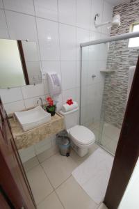 a bathroom with a toilet and a sink and a shower at Pousada Maragolfinho in Maragogi