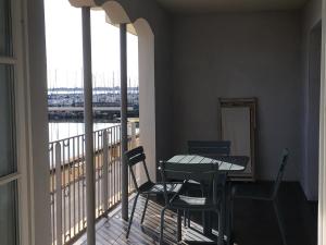 a balcony with a table and chairs and a view at Port Rive Gauche Roseliere in Marseillan