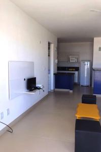 - un salon avec un canapé, une table et un réfrigérateur dans l'établissement Varandas da Praia Apartamentos, à Porto Seguro