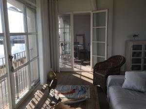 a living room with a couch and a table and windows at Port Rive Gauche Roseliere in Marseillan