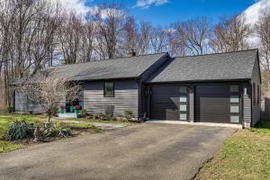 a house with a garage and a driveway at Charming Connecticut Hideaway: Year-Round Fun! in Middlefield