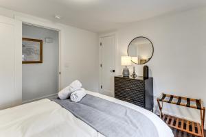 a bedroom with a bed with a mirror and a chair at Charming Connecticut Hideaway: Year-Round Fun! in Middlefield