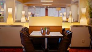 a table with chairs and glasses on it in a restaurant at Radisson Blu Hotel Olümpia in Tallinn