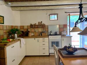 a kitchen with white appliances and a table with a bowl of fruit at Can Peñes in Port d'Andratx +15 photos