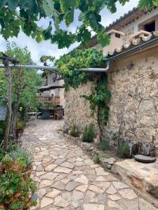 a stone house with a stone walkway in a yard at Can Peñes in Port d'Andratx