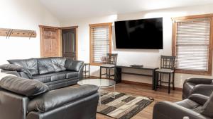 ein Wohnzimmer mit Ledermöbeln und einem Flachbildfernseher in der Unterkunft Overlook in Valemount