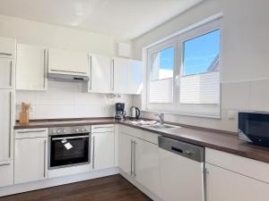a white kitchen with white appliances and windows at 1380- Annina 3 in Dahme