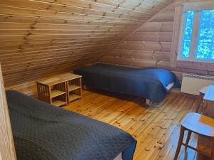 a bedroom with two beds in a log cabin at Jämsän Lomamökit in Jämsä