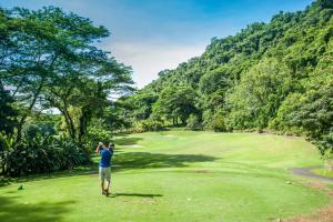 a man standing on a golf course looking at a green at Veranda 3G 2 bdr Garden View in Los Suenos in Jacó