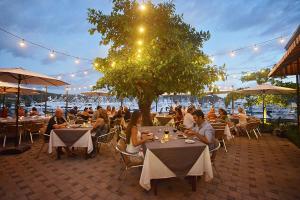 a group of people sitting at tables in a restaurant at Veranda 3G 2 bdr Garden View in Los Suenos in Jacó