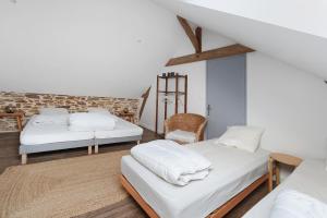 a living room with two beds and a chair at Bulle de Douceur avec Spa in Vallons-de-l'Erdre