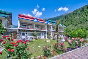 a house with flowers in the yard at Parhena Cottages Bella Naran in Naran