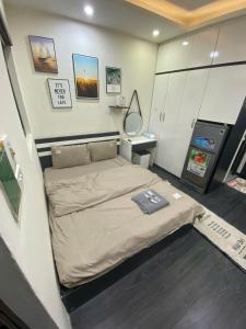 a small bedroom with a bed and a mirror at Amoureux Cầu Diễn in Tây Tựu