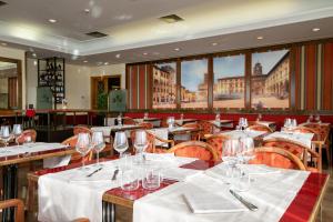 a restaurant with tables and chairs with wine glasses at Etrusco Arezzo Hotel - Sure Hotel Collection by Best Western in Arezzo