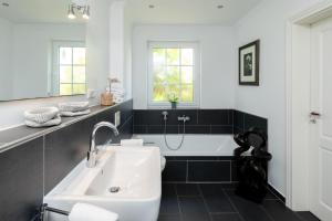 a bathroom with a sink and a bath tub at Ant Diekskant in Juist +42 photos