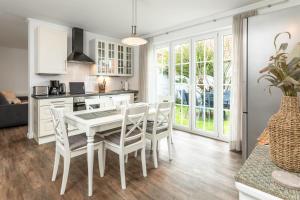 a kitchen and dining room with a white table and chairs at Ant Diekskant in Juist