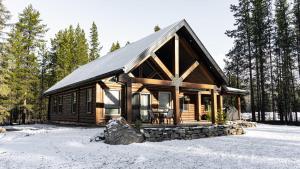 a log cabin in the woods in the snow at The Highmark Cabin in Valemount