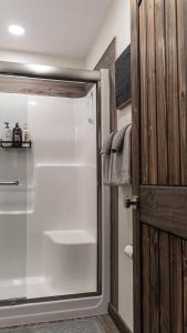 a shower with a glass door in a bathroom at The Highmark Cabin in Valemount +21 photos