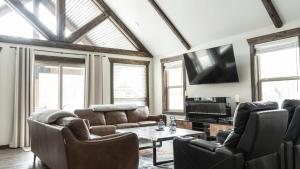 a living room with leather furniture and a flat screen tv at The Highmark Cabin in Valemount