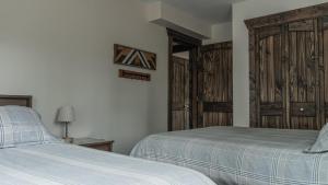 a bedroom with two beds and wooden doors at The Highmark Cabin in Valemount
