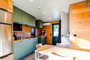 a kitchen with green cabinets and a wooden table at Chalet Prestige 56 in Rivières +9 photos