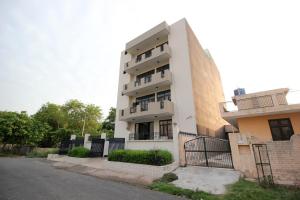 a tall white building next to a street at Hotel O Staysnap in Indirapuram