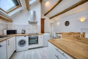 a kitchen with white appliances and a wooden counter top at COLIVING - bedroom - TV- Private Bathroom in Saint-Jean-de-Gonville