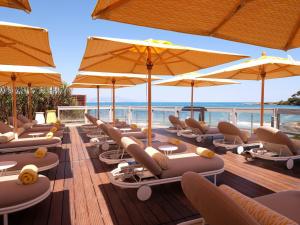 a row of lounge chairs and umbrellas on a beach at Villa Miraé by Inwood Hotels - Cap d'Antibes in Antibes