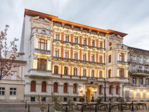 a large yellow building with a clock on it at Hotel Traugutta 12 in Łódź