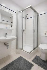 a bathroom with a shower and a toilet and a sink at Terrasse Double Studio Apartments in Lübeck +98 photos