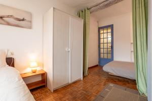 a bedroom with a bed and a bed and a door at La Petite Maison in Puimoisson