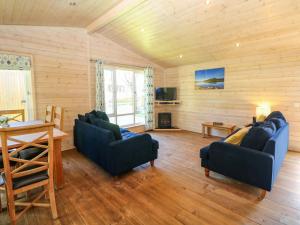 a living room with two blue couches and a table at Dovestone Luxury Lodges sleeps 6 - pet free in Oldham