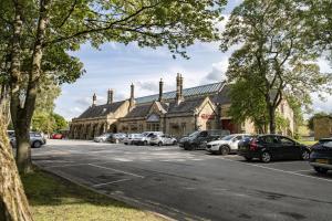 a large building with cars parked in a parking lot at Boar Edge Cottage in Richmond +26 photos