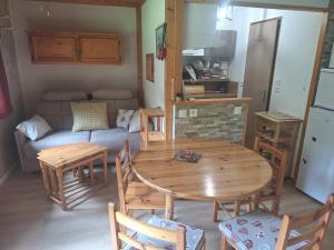 a living room with a wooden table and a couch at Duplex au calme vue montagne in Abondance +6 photos