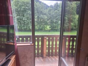 an open door to a balcony with a view of trees at Duplex au calme vue montagne in Abondance