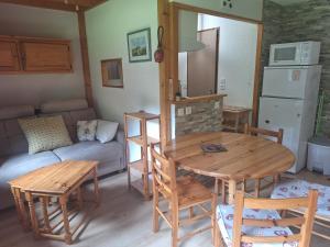 a living room with a table and chairs and a couch at Duplex au calme vue montagne in Abondance