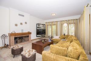 a living room with a couch and a fireplace at Villa Valentina by Algarve Holidays in Almancil