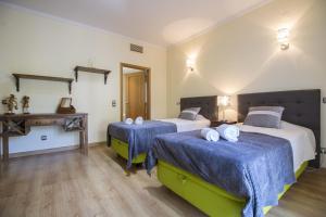 a bedroom with two beds with blue sheets and a table at Villa Valentina by Algarve Holidays in Almancil +60 photos