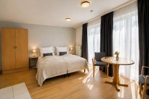 a hotel room with a bed and a table and window at Terrasse Double Studio Apartments in Lübeck