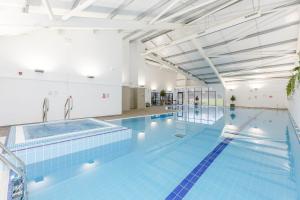 a large indoor swimming pool with a large swimming pool at Pine Lodge Spa in Thirsk