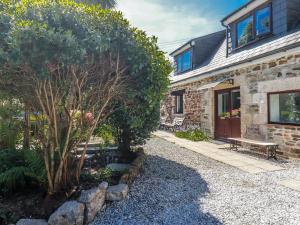 a stone house with a bench in front of it at Hydrangea Cottage in St Austell